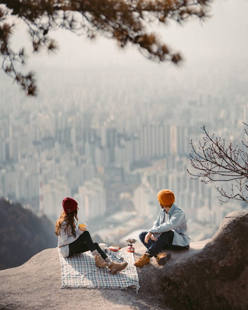 couple having a picnic on a cliff overlooking a city